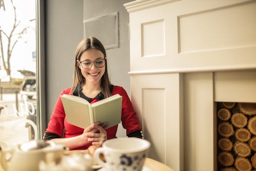 A person taking a break with a cup of tea and a book